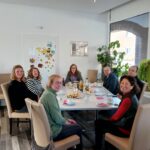 Gruppe von Frauen und Männern um einen Tisch. Die Kümmer:innen die die Tauschbox ehrenamtlich führen.