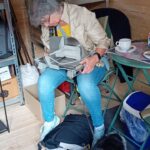 Damen mit Hund in der Tauschbox sitzend, die eine Brotschneidemaschine anschaut